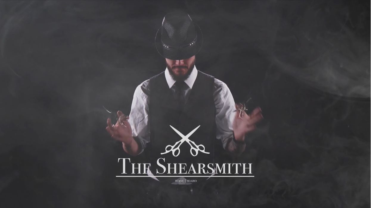 The Shearsmith. Man with smoke around him in a hat with scissors in hands.