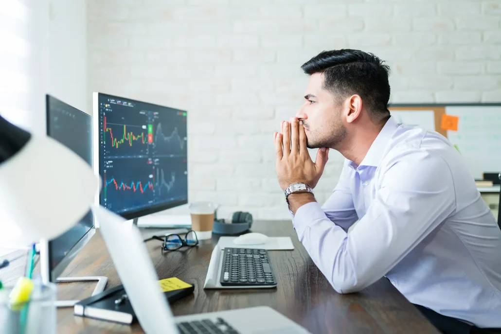 A finance professional watching an uncertain stock market fluctuate