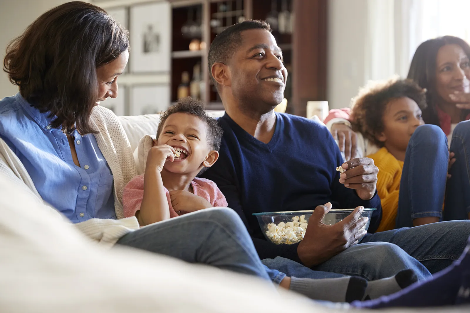 Multi generational family on sofa watching streaming television.